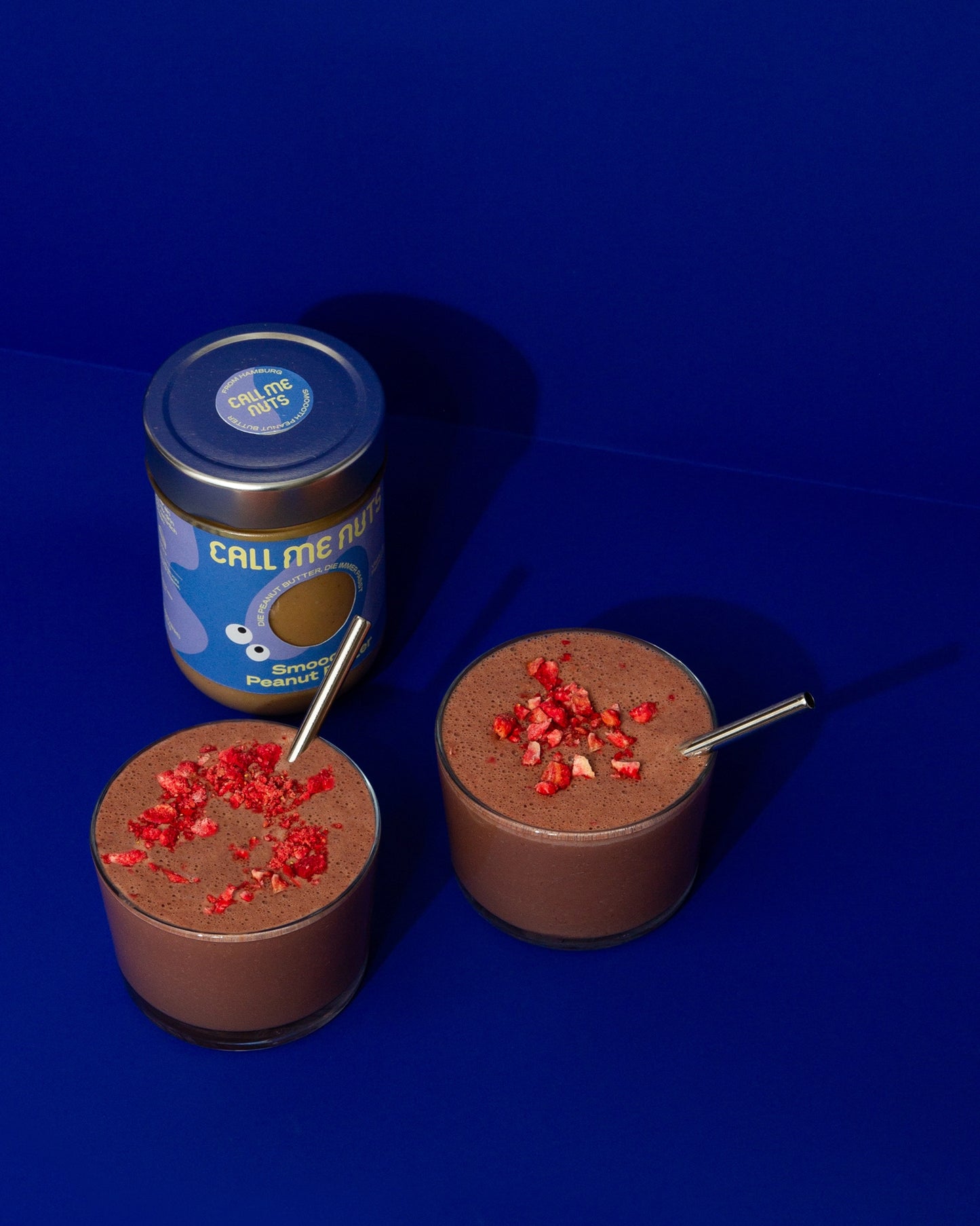 Chocolate Smoothie mit Smooth Peanut Butter Glas vor blauem Hintergrund