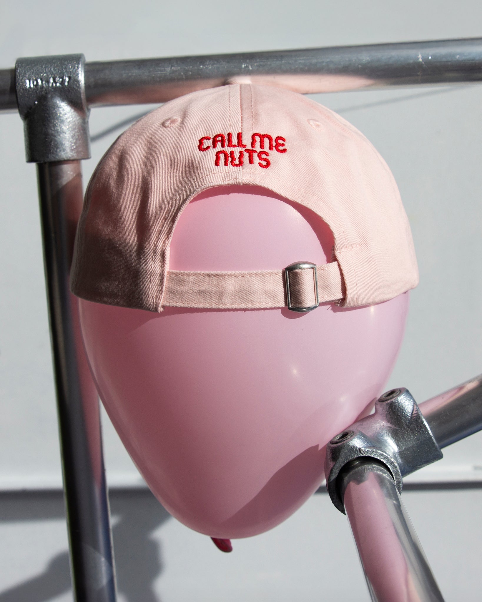 Rosa Cap von hinten auf rosa Ballon mit rotem CALL ME NUTS Stick