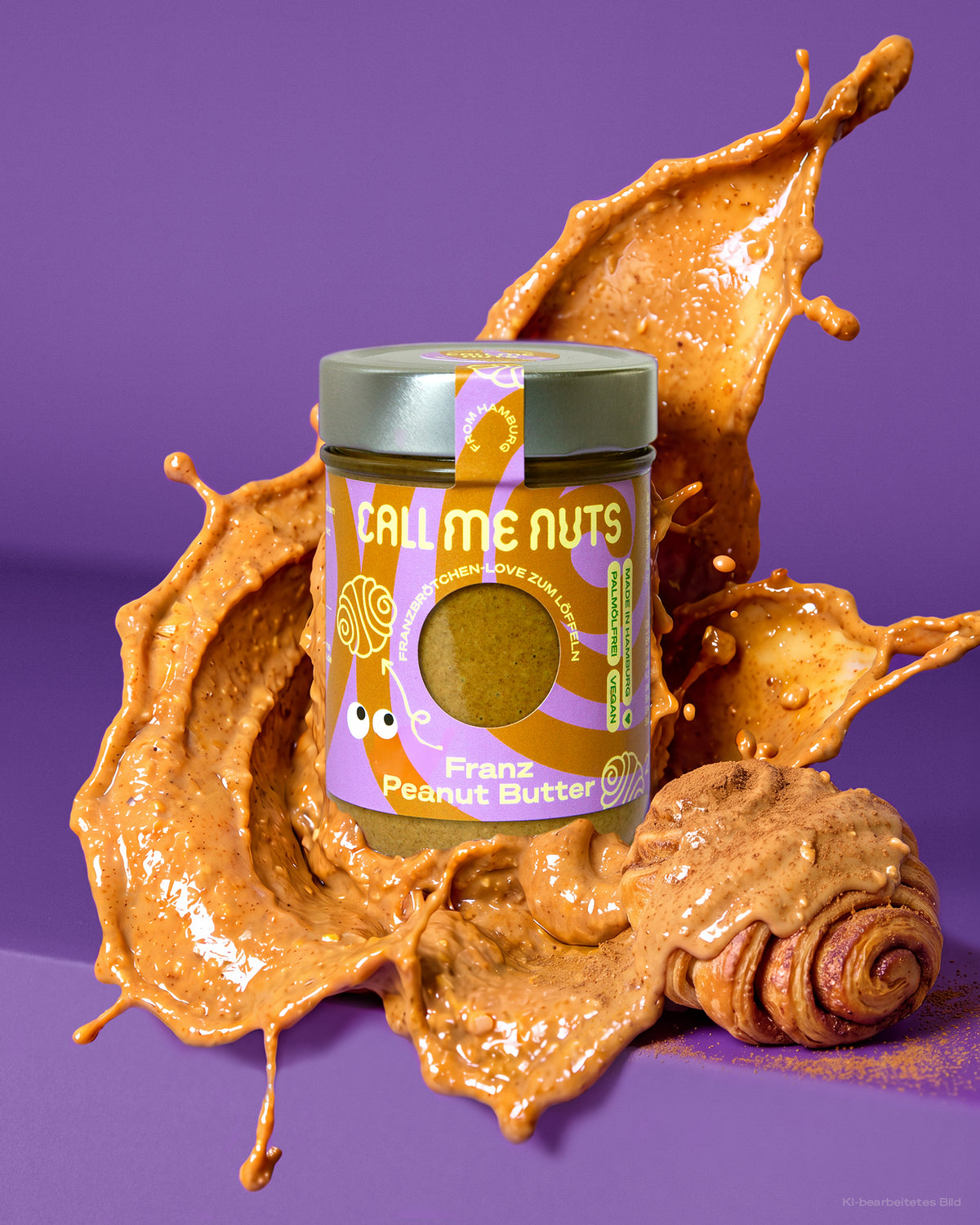 FRANZ Erdnussbutter mit Zimt und Tonkabohne im Glas neben einem Franzbrötchen und ein Splash Erdnussbutter hinter dem Glas