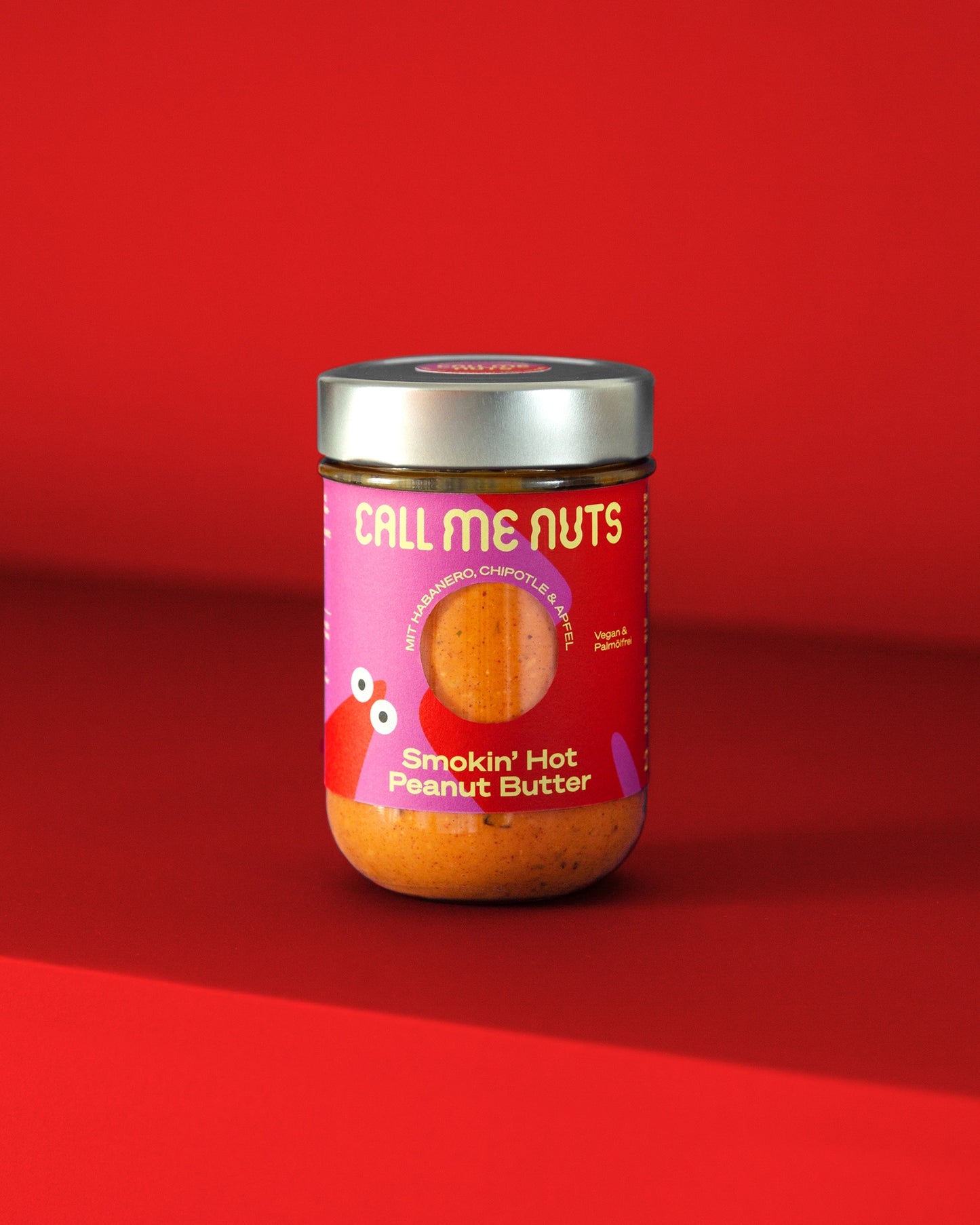 Smokin' Hot Peanut Butter Glas auf rotem Hintergrund