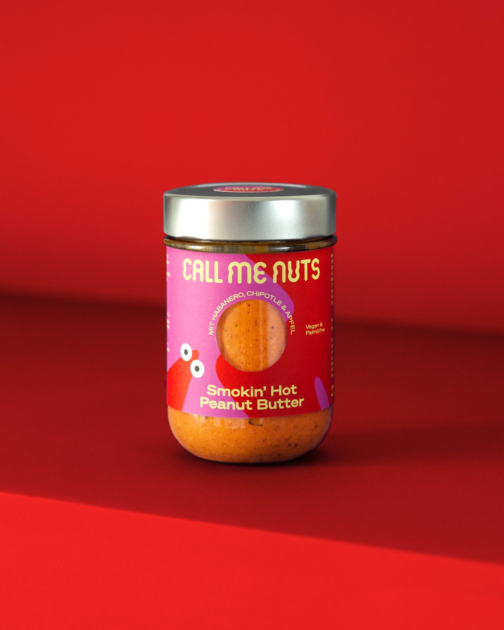 Smokin' Hot Peanut Butter Glas auf rotem Hintergrund